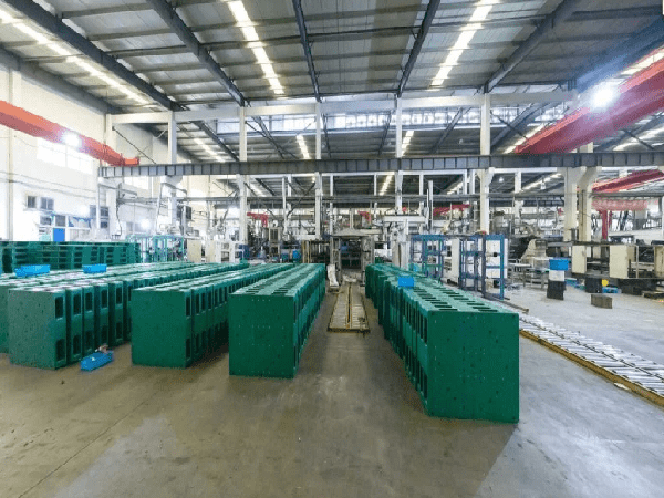 An industrial factory filled with machinery, where rows of green plastic pallets are neatly arranged, indicative of the production capabilities of top plastic pallet manufacturers in Bangladesh.