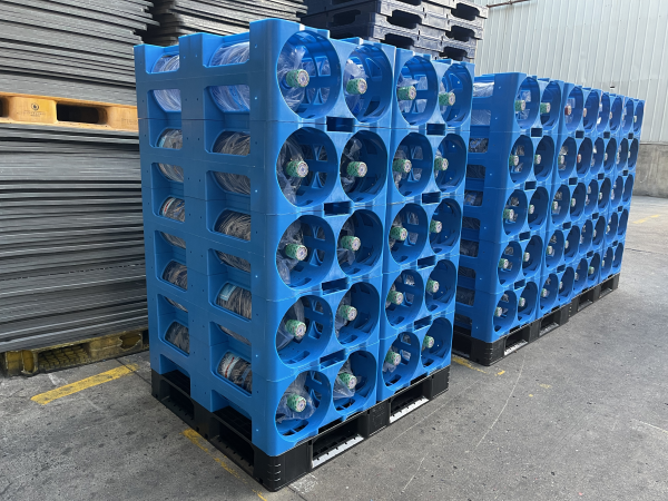 5 gallon water bottles stored on blue plastic water bottle rack for palletized transport