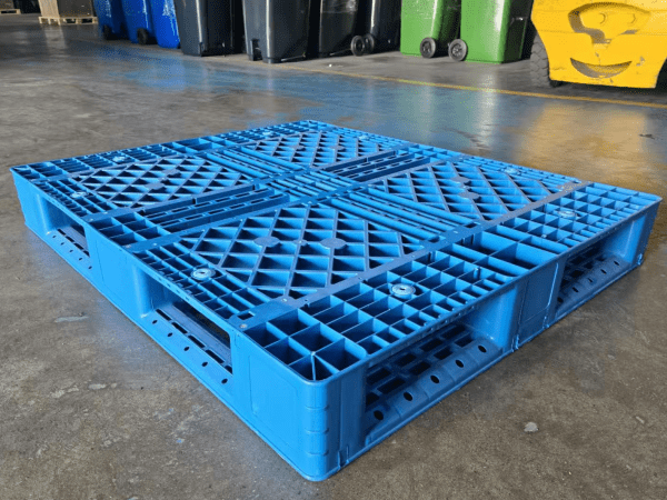 A blue plastic pallet in a warehouse, relevant to UK plastic pallet sizes and logistics compatibility.