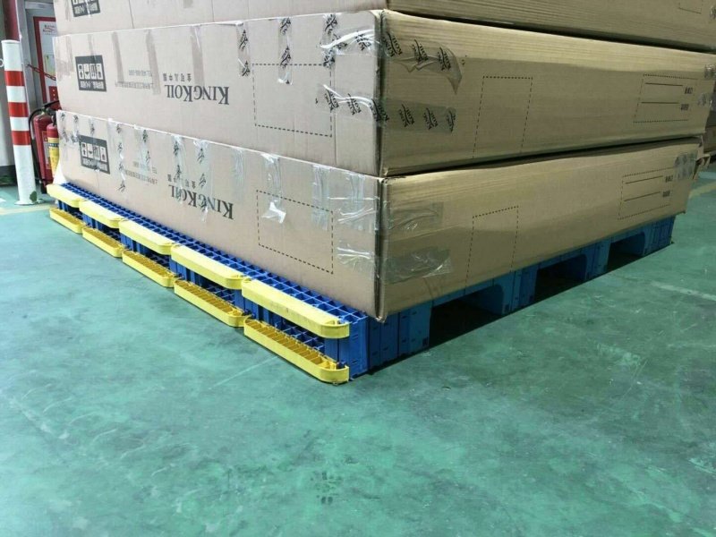 Big boxes on blue splicing modular plastic pallets, home appliance logistics.