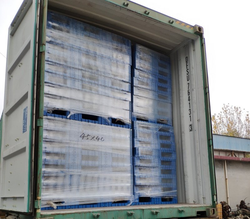 Blue plastic pallets stacked and wrapped in a container, showing stacking method for transport.