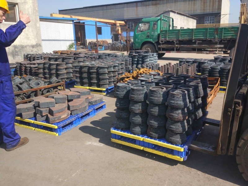 Blue splicing pallets hold machinery parts, used in manufacturing, industrial setting.