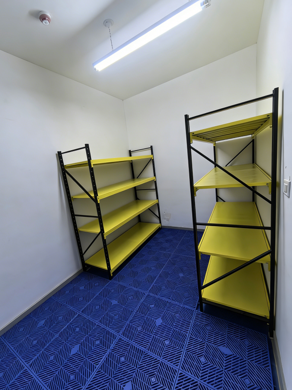 blue plastic floor pallets covering warehouse floor with empty shelving