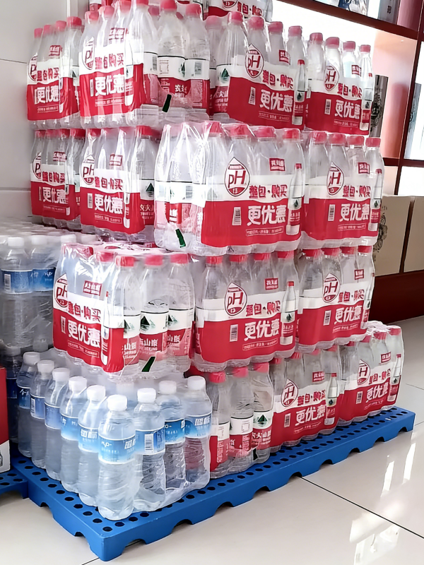 bottled water temporarily stored on blue plastic floor pallets