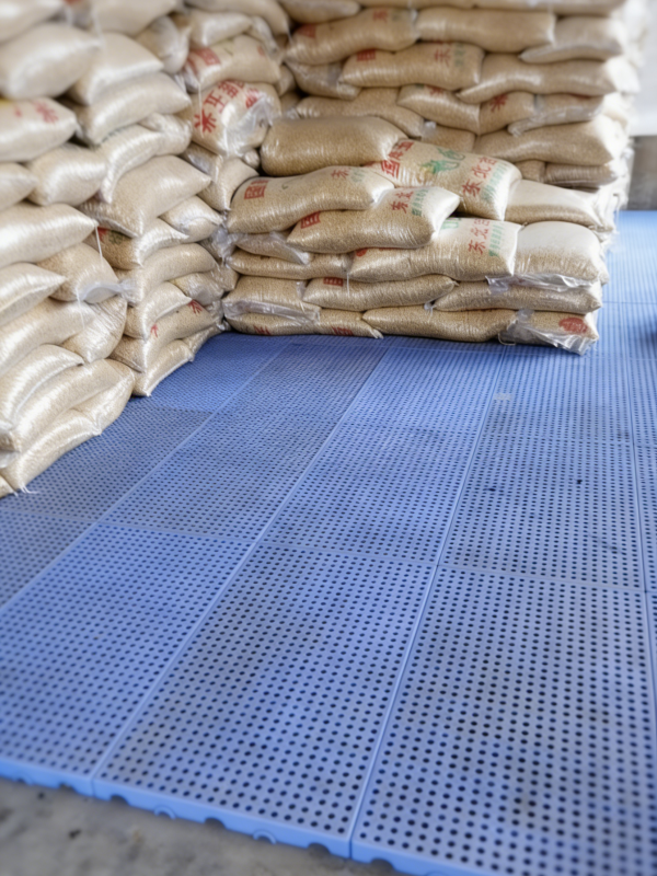 rice sacks stored on blue plastic floor pallets in warehouse