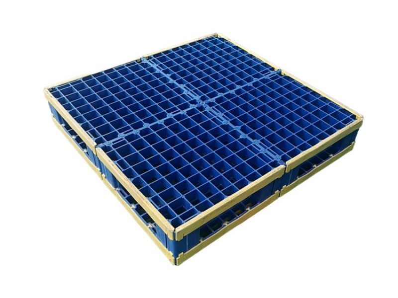 The blue double-sided modular plastic splicing pallet, with yellow protective edges, is placed on the factory floor.