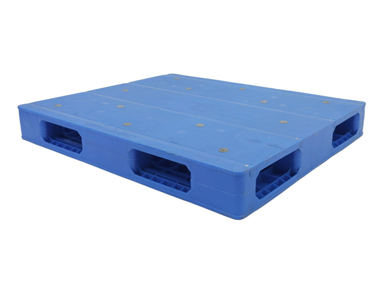 Una paleta de plástico sólido reversible de alta resistencia y color azul, diseñada para uso rudo, con una superficie sólida y múltiples aberturas para acceso de montacargas.