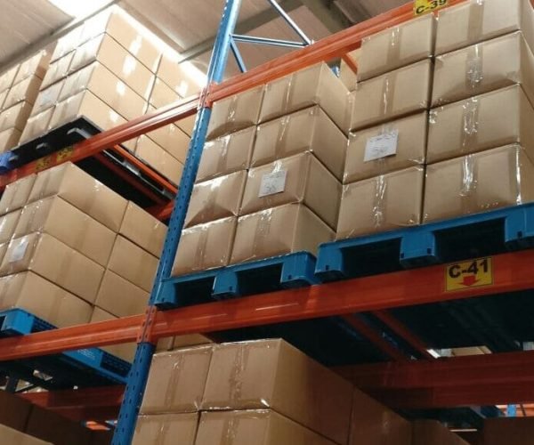 pallet for racking use Industrial plastic pallets supporting cardboard boxes on racks in a warehouse, demonstrating storage functionality.
